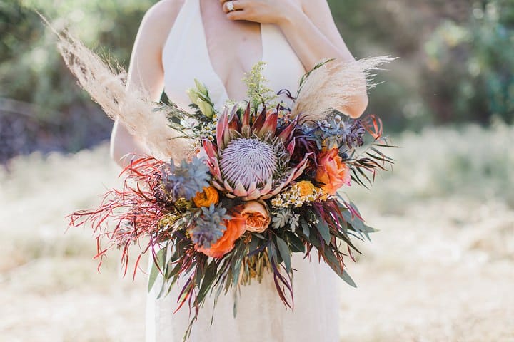 Bride holding a vibrant protea and pampas bouquet